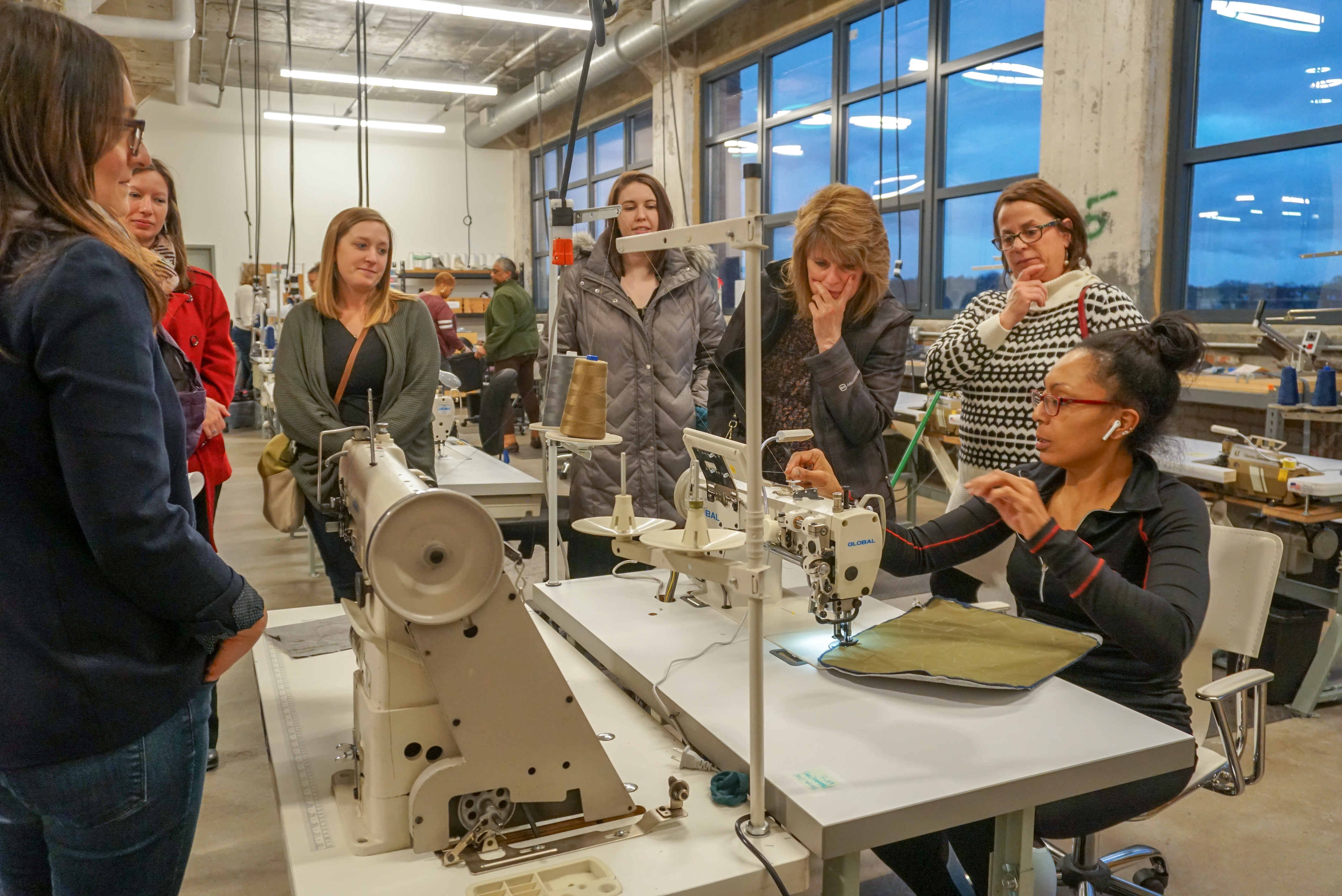A Thread worker shows the sewing machine process to the Green Team